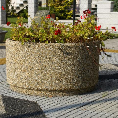 Duża, okrągła donica zewnętrzna MIRA wykonana w technologii betonu płukanego z charakterystyczną warstwą odsłoniętego kruszywa naturalnego.