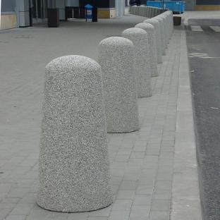 Pal parkingowy o średnicy 43 cm oraz wysokości 82 cm, wyrób wykonany w technologii betonu płukanego.